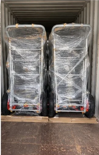 Finished heavy platform trucks strapped and loaded inside an export container