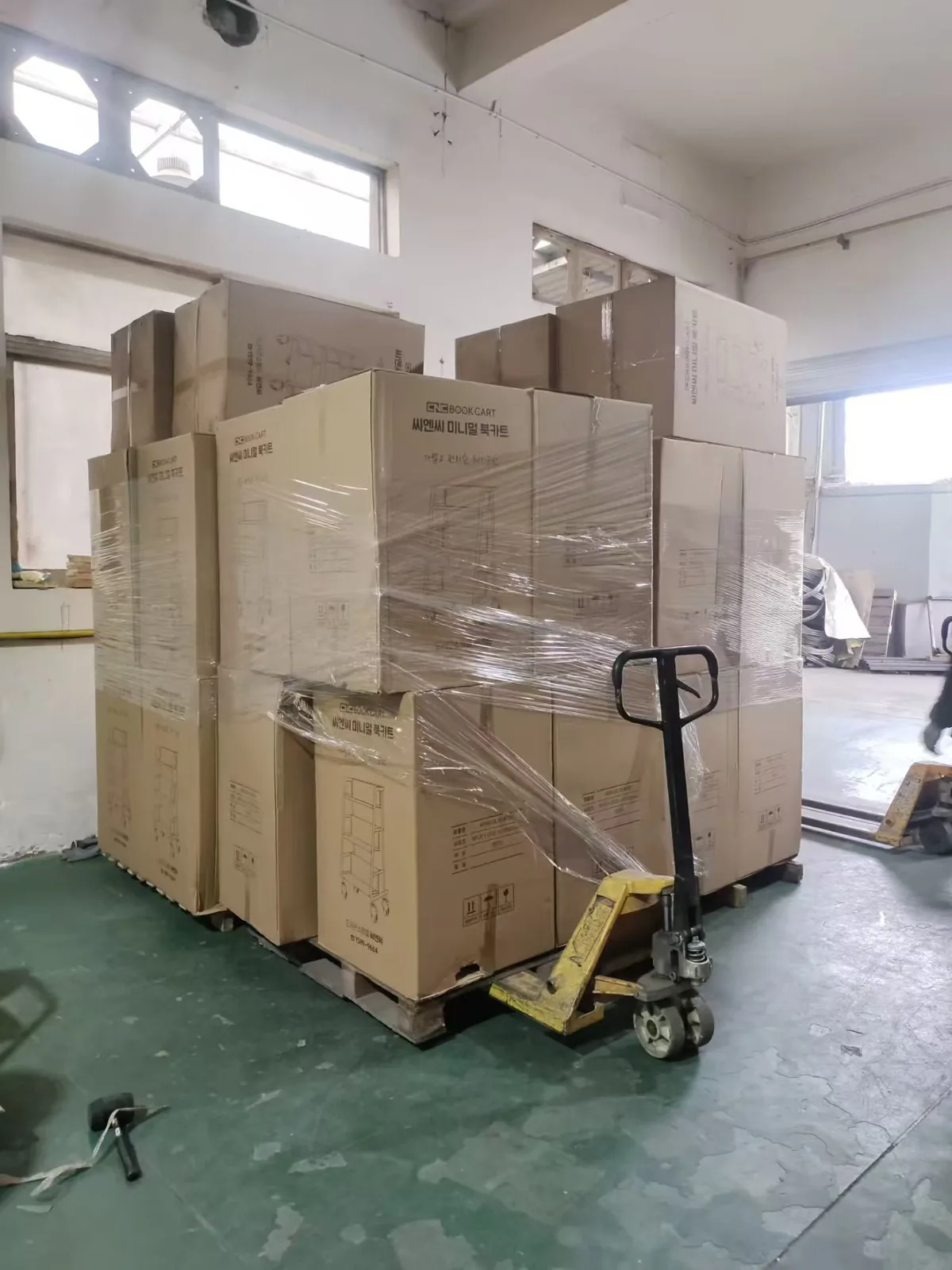 Cartons and totes staged beside trolleys in a warehouse