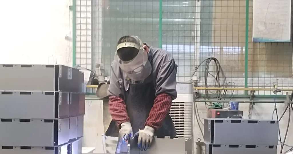 Welder building a sheet metal frame at the welding station