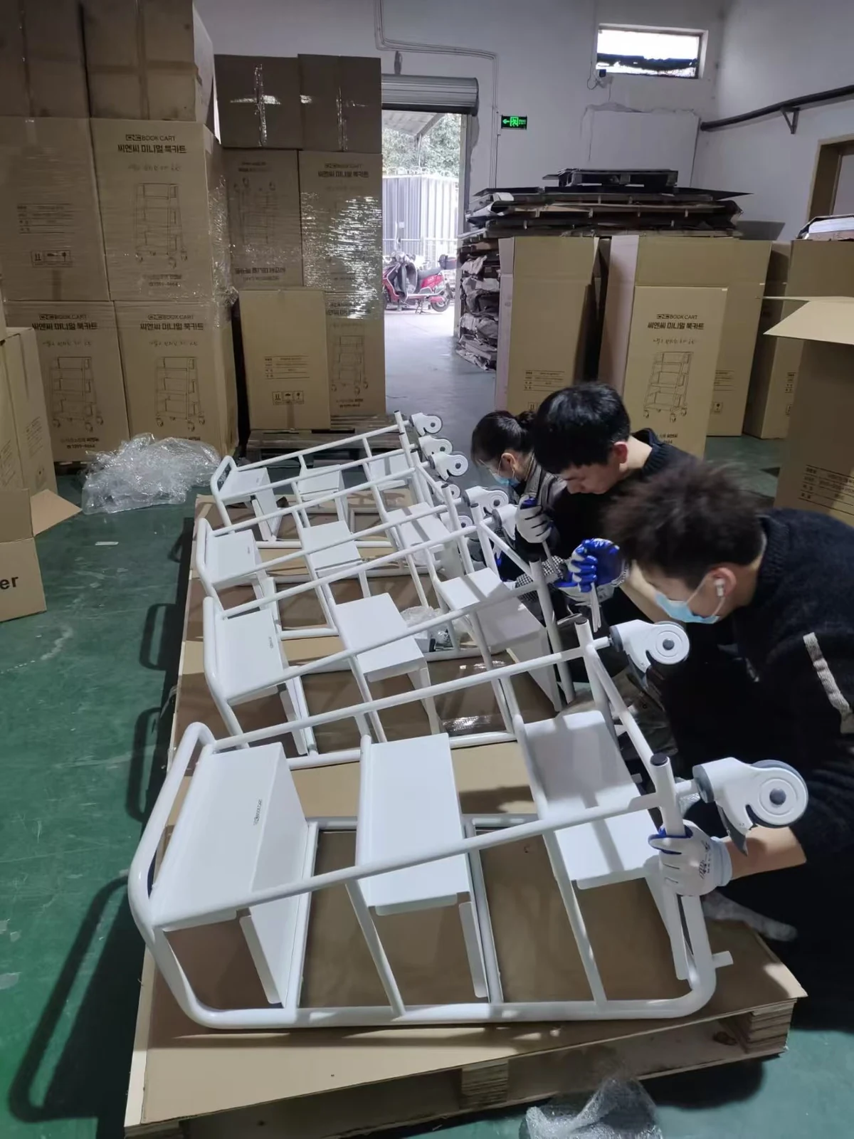 Batch assembly of white library book trolleys at our factory in Ningbo, China